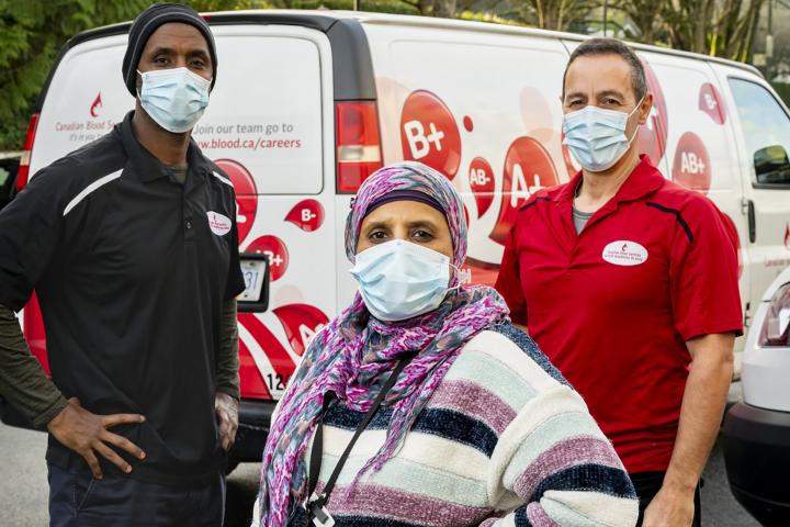 Three health care workers with vehicle