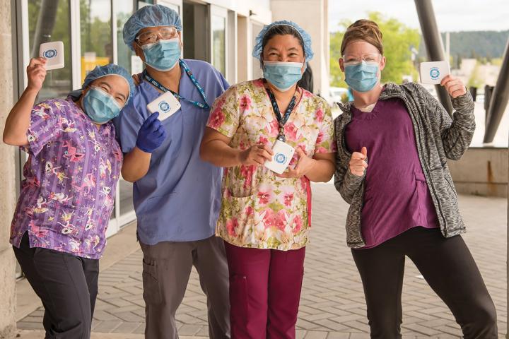 Four nurses posing for a picture with masks