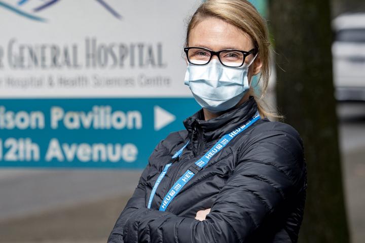 HEU member standing in front of workplace