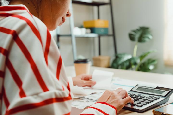 Woman working with calculator on table