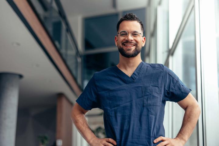health care worker in scrubs standing in hall