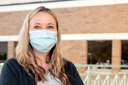 nursing unit clerk with mask in front of hospital