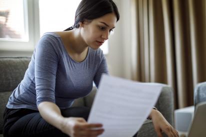 Woman reading form in front of computer