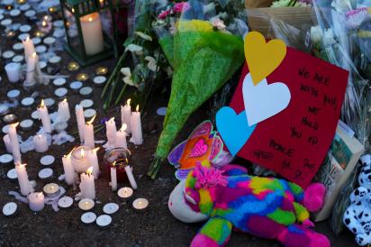 Candles and flowers placed on the ground