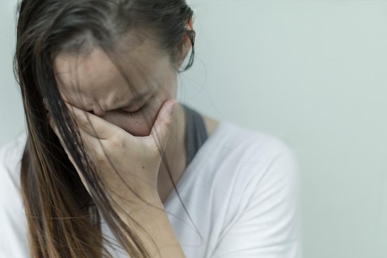 Women covering her face with hand