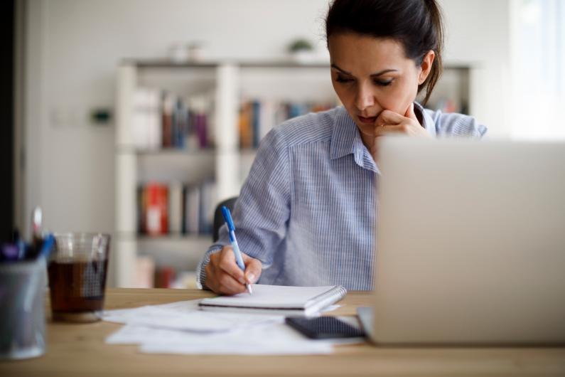 Woman with laptop writing