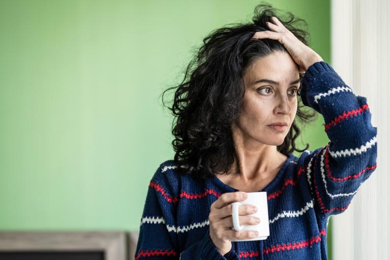 Distressed woman looking out window