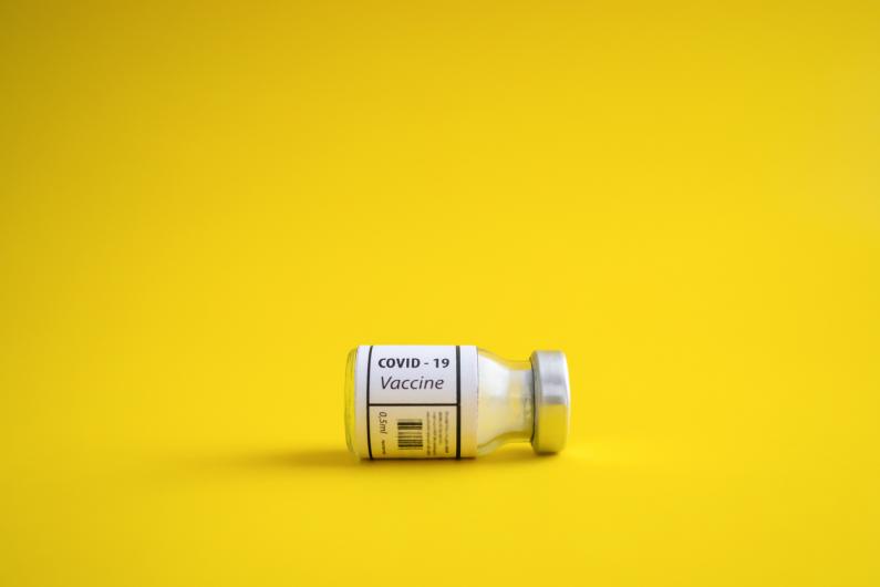 vaccine vial on yellow background