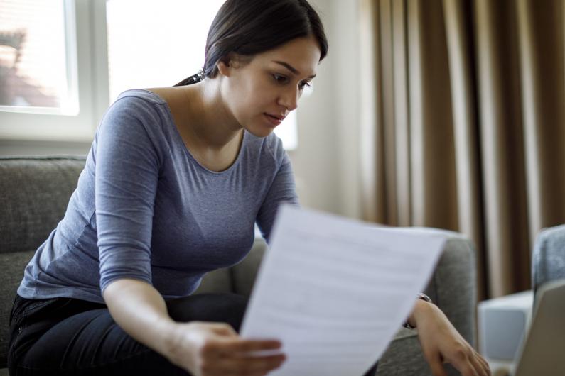 Woman reading form in front of computer