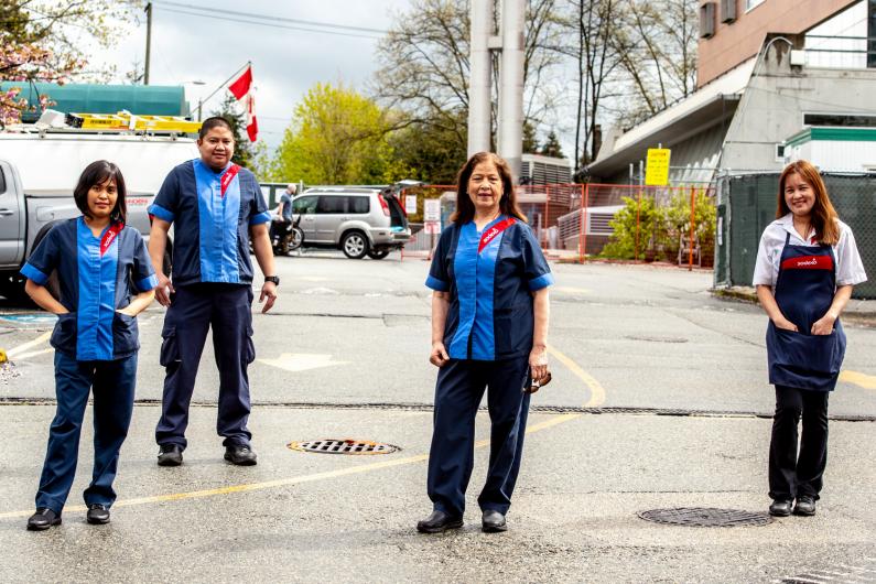 four food service members standing outside hospital