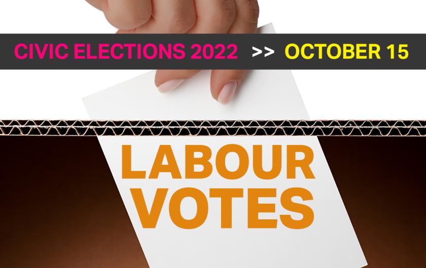 Hand putting ballot into a ballot box. Labour votes is written on the ballot box.